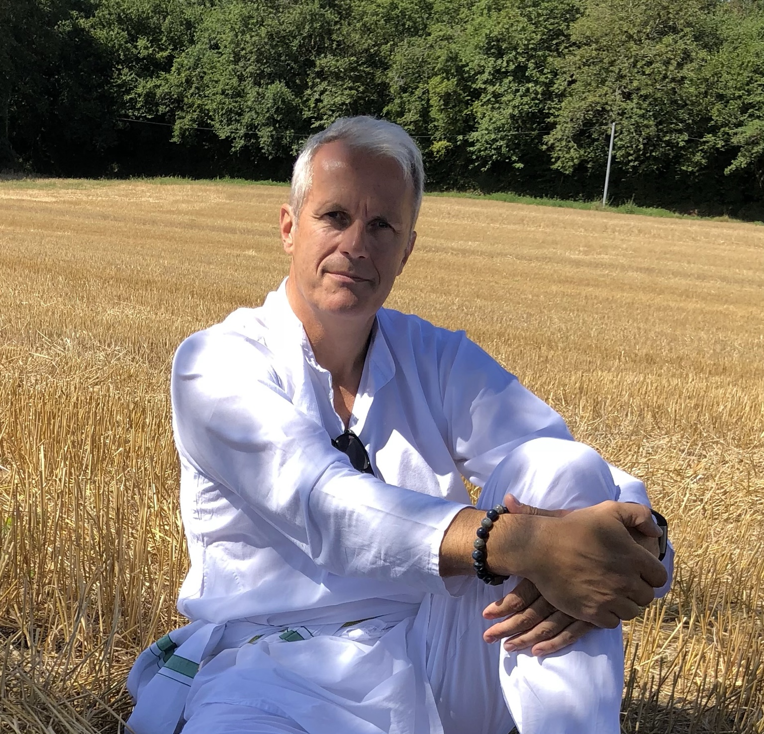 Mark Elliot sitting in a sunlit field