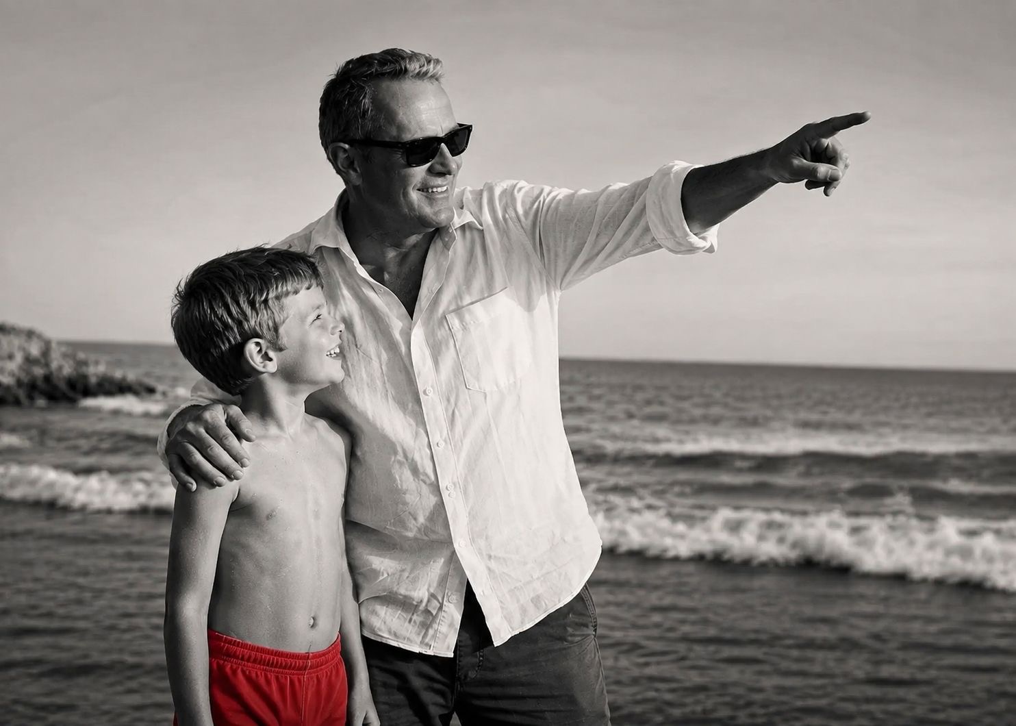 Mark Elliot beside a young boy in red swimming trunks